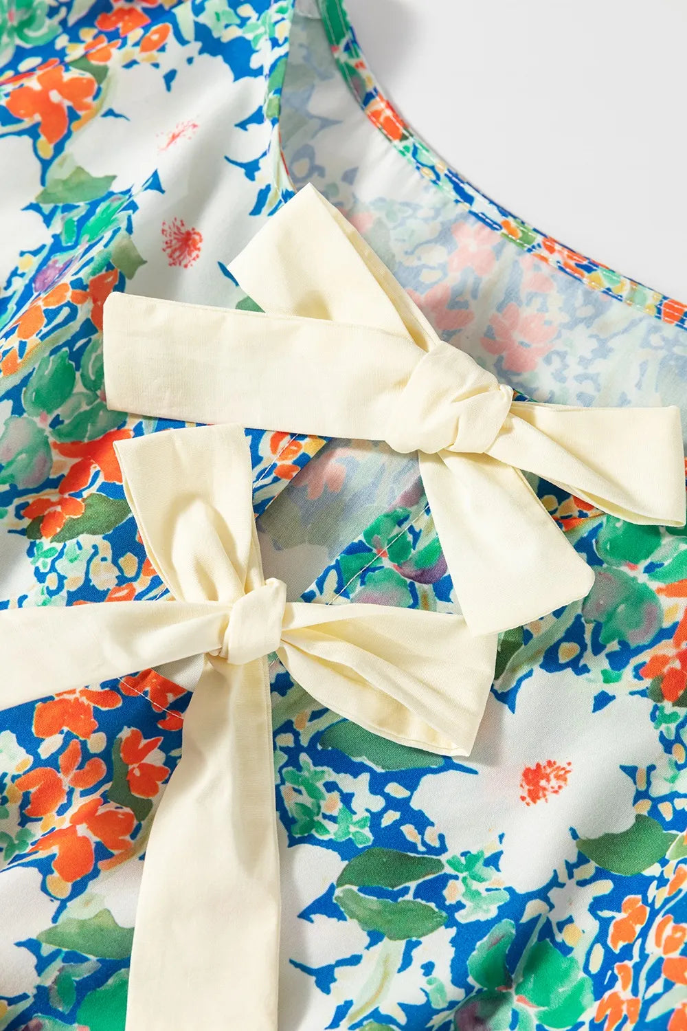 Floral Print Bow Applique Slit Sleeveless Peplum Blouse DAME BOHEME
