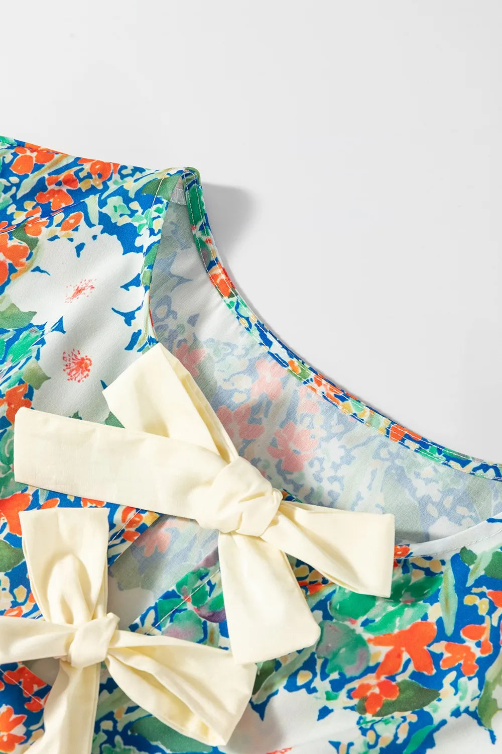 Floral Print Bow Applique Slit Sleeveless Peplum Blouse DAME BOHEME